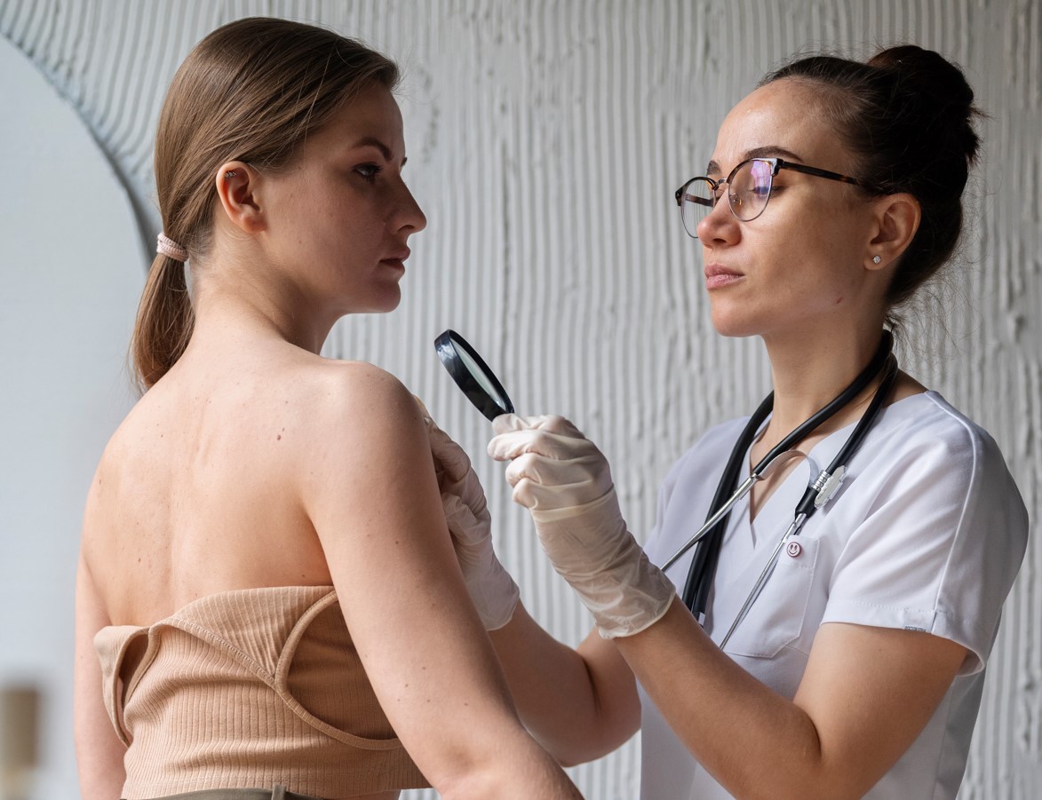 Mulher com blusa abaixada seno avaliada por médica para avaliar possíveis sintomas de câncer de mama.