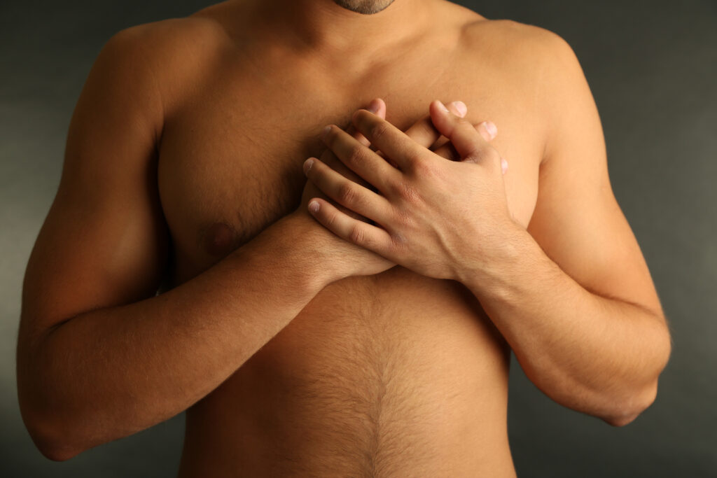 Câncer de mama em homens: esclarecendo mitos e orientando a prevenção Homem realizando autoexame das mamas para detecção precoce de câncer de mama em homens — conscientização sobre saúde masculina.